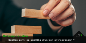 Devenir entrepreneur Main posant un bloc de bois sur un escalier de blocs, avec le texte « Quelles sont les qualités d’un bon entrepreneur ? »